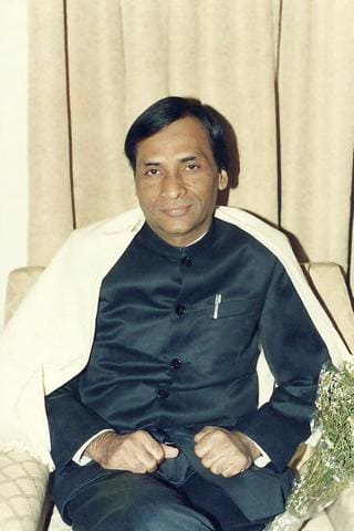 Earlier portrait of Kavi Narayan Agrawal seated in a dark bandhgala