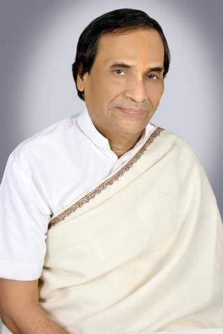 Studio portrait of Kavi Narayan Agrawal in a white kurta and cream shawl